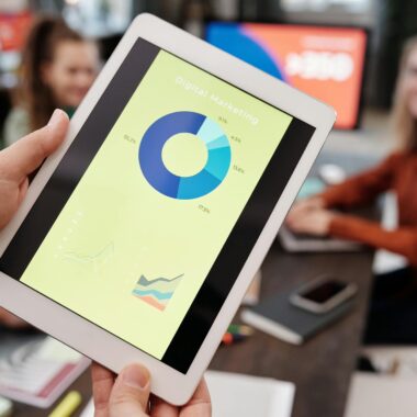 Business team reviewing digital marketing statistics on a tablet during an indoor meeting.