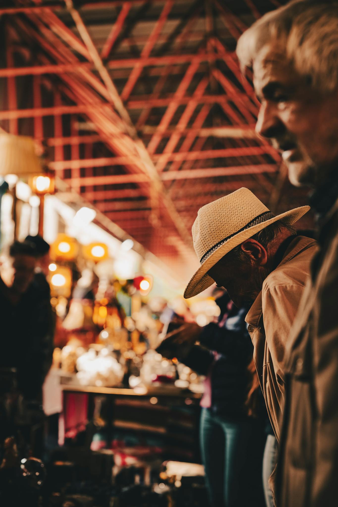 Two senior men at a bustling indoor market in Ankara, Türkiye.